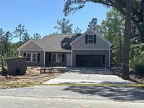 Charming single-story home with gray siding, a two-car garage, and a newly poured concrete driveway at 8545 Pee Dee Hwy., Conway, SC 29527