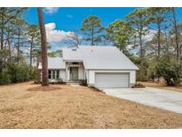 Charming single-story home featuring a light gray exterior, metal roof, and a well-maintained front yard at 144 Springfield Rd., Pawleys Island, SC 29585