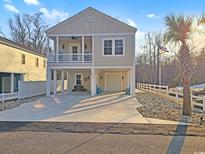 Charming two-story home featuring a covered porch and garage with spacious driveway and landscaping at 1825 24Th Ave. N, North Myrtle Beach, SC 29582