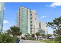 Modern high-rise building features sleek architectural design and verdant palm trees around the property at 201 S Ocean Blvd. # 217, Myrtle Beach, SC 29577