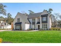 Stunning two-story home featuring a modern farmhouse design, manicured lawn, and sophisticated landscaping at 208 Green Lake Dr., Myrtle Beach, SC 29572
