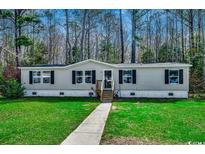 Charming home featuring a well-maintained lawn and a inviting walkway leading to the front door at 24 Majors Ct., Pawleys Island, SC 29585