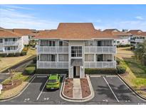 Exterior view of a well-maintained two-story condo with a parking lot and manicured landscaping at 300 Shorehaven Dr. # W-3, North Myrtle Beach, SC 29582