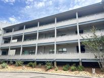 Spacious condo complex with multiple balconies, lush landscaping, and ample parking at 310 5Th Ave. N # 206, Surfside Beach, SC 29575