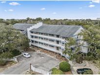 Scenic view of a condo complex with ample parking and surrounded by lush trees at 310 5Th Ave. N # 206, Surfside Beach, SC 29575