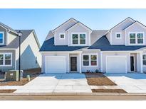 Charming townhome featuring a one-car garage, neutral siding, and a well-manicured front yard at 312 Brackish Dr. # 312, Myrtle Beach, SC 29588
