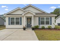 Charming one-story home featuring light siding, blue shutters, and a well-maintained front yard at 3500 Church St., Loris, SC 29569
