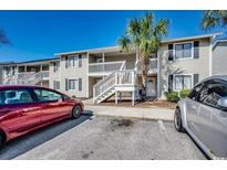 Exterior of a two-story condo building featuring white staircases and a palm tree at 3555 Highway 544 # 4-C, Conway, SC 29526