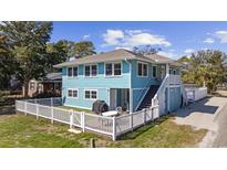 Charming two-story home with a white picket fence and outdoor patio area, perfect for entertaining at 401 25Th Ave. S, North Myrtle Beach, SC 29582