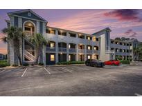 Condo exterior with private balconies, palm trees, and ample parking under a vibrant sky at 4503 W Harbour Ct. # S-6, Little River, SC 29566