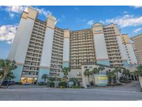 View of condo building with a sign, manicured landscaping and palm trees at 4800 Ocean Blvd. S # 323, North Myrtle Beach, SC 29582