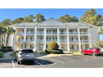 Traditional condo building featuring white columns, multiple balconies, and well-maintained landscaping at 5000 Windsor Green Way # 204, Myrtle Beach, SC 29579
