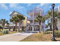 Bright beach house featuring multiple levels, decks, palm trees, and convenient ground-level parking at 512-B Ocean Blvd. S, Surfside Beach, SC 29575