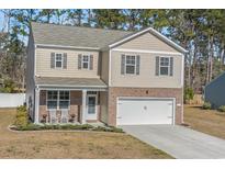 Charming two-story home with a brick-accented front and a well-manicured lawn at 55 Porch Ln., Pawleys Island, SC 29585