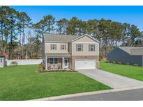 Charming two-story home with a manicured lawn and inviting front porch with rocking chairs at 55 Porch Ln., Pawleys Island, SC 29585