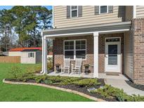 Charming brick front porch with rocking chairs and manicured landscaping at 55 Porch Ln., Pawleys Island, SC 29585
