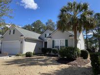 Charming single-story home with well-maintained landscaping and a stately palm tree in the front yard at 7471 Balmore Dr. Sw, Sunset Beach, NC 28468