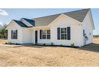 Inviting new construction home with white siding, black shutters, and a well-manicured lawn at 813 Highway 67, Loris, SC 29569