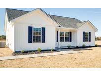 Charming home features white siding, black shutters, and a well-manicured lawn at 825 Highway 67, Loris, SC 29569