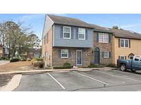 Charming townhome with brick facade, blue shutters, manicured landscaping and dedicated parking at 830 44Th Ave. N # U1, Myrtle Beach, SC 29577