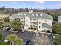 Aerial view of a three-story building with dormer windows and a parking lot with palm trees at 1033 World Tour Blvd. # 101-A, Myrtle Beach, SC 29579