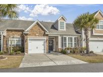 Charming townhome with stone accents, well-manicured lawn, and attached one-car garage at 113 Parmelee Dr. # D, Murrells Inlet, SC 29576