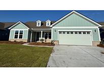 Charming single-story home with an attached two car garage, manicured lawn, and a coastal color palette at 1333 Crested Iris Way, North Myrtle Beach, SC 29582