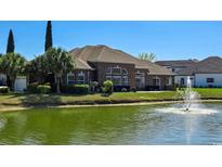 Brick home exterior showcasing manicured lawn, patio, and serene water view with fountain at 1624 Portwest Dr., Myrtle Beach, SC 29579