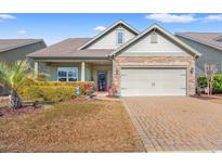 Charming home featuring a well-manicured lawn, brick driveway, and a welcoming two-car garage at 1837 Orchard Dr., Myrtle Beach, SC 29577