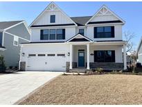 Charming two-story home showcasing a blue front door, white facade, and a two-car garage at 2317 Hazel Way, Longs, SC 29568