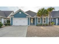 Charming single Gathering home with blue siding, a two-car garage and well-maintained landscaping at 2323 Tidewatch Way, North Myrtle Beach, SC 29582