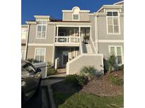 Inviting exterior with a staircase leading to the second-story entrance and landscaped yard at 4396 Baldwin Ave. # 141, Little River, SC 29566