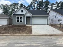 Charming gray one-story home with a two-car garage and contemporary architectural details at 444 Sun Colony Blvd., Longs, SC 29568
