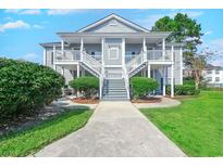 Charming condo featuring double balconies, landscaped grounds, and inviting walkway to entrance at 5026 Belleglen Ct. # 201, Myrtle Beach, SC 29579