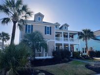 Charming two-story home with a double balcony, inviting curb appeal, palm trees, and manicured lawn at 5220 Mount Pleasant Dr., Myrtle Beach, SC 29579