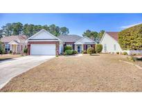 Charming single-story home featuring a brick facade, attached garage, and manicured landscaping at 664 Pamlico Ct., Myrtle Beach, SC 29588