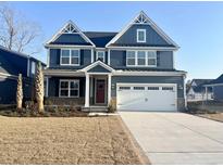 Beautiful two-story home features a symmetrical design, blue siding, and a spacious two-car garage at 9021 Aria Way, Longs, SC 29568