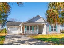 Charming single-story home with a well-manicured lawn, attached garage, and covered front porch at 125 Dayglow Dr., Loris, SC 29569