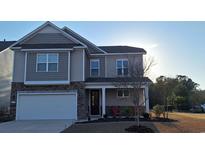 Two-story home with stone accents, landscaped yard, and attached two-car garage at 1330 Reflection Pond Dr., Little River, SC 29566