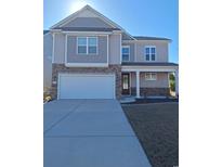 Charming two-story home with neutral siding, stone accents, covered porch, and an attached two-car garage at 1330 Reflection Pond Dr., Little River, SC 29566