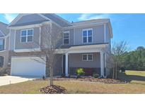 Charming two-story home boasts stone accents, a welcoming porch, and meticulous landscaping at 1330 Reflection Pond Dr., Little River, SC 29566
