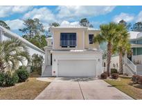 Charming two-story home featuring a well-manicured yard, driveway, and beach inspired color scheme at 141 Spendor Circle, Murrells Inlet, SC 29576