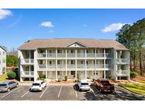 Three-story condo building with white siding, wooden railings, and parking in front at 1440 Blue Tree Ct. # N, Myrtle Beach, SC 29588