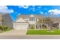 Charming two-story white home with a manicured lawn, a two car garage, and inviting curb appeal at 2526 Great Scott Dr., Myrtle Beach, SC 29579