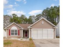 Charming single-story home featuring a well-maintained lawn, two-car garage, and inviting front porch at 310 Junco Circle, Longs, SC 29568