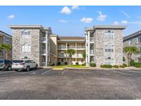 Attractive condo complex with balconies, palm trees, and ample parking on a beautiful, sunny day at 4701 Wild Iris Dr. # 16-204, Myrtle Beach, SC 29577