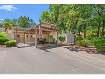 Charming covered parking area with golf cart and American flag provides convenient and stylish parking at this home at 490 Ocean Creek Dr. # 8, Myrtle Beach, SC 29572