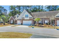 Inviting brick townhome featuring a two-car garage and manicured landscaping for exceptional curb appeal at 5042 Forsythia Circle # 5042, Murrells Inlet, SC 29576
