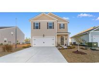 Charming two-story home with a modern exterior, attached garage, and well-manicured lawn and landscape at 706 Gryffindor Dr., Little River, SC 29566