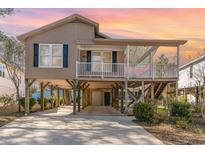 Charming beach home with stilt foundation, covered porch, and driveway at 813 Starboard Ct., Murrells Inlet, SC 29576